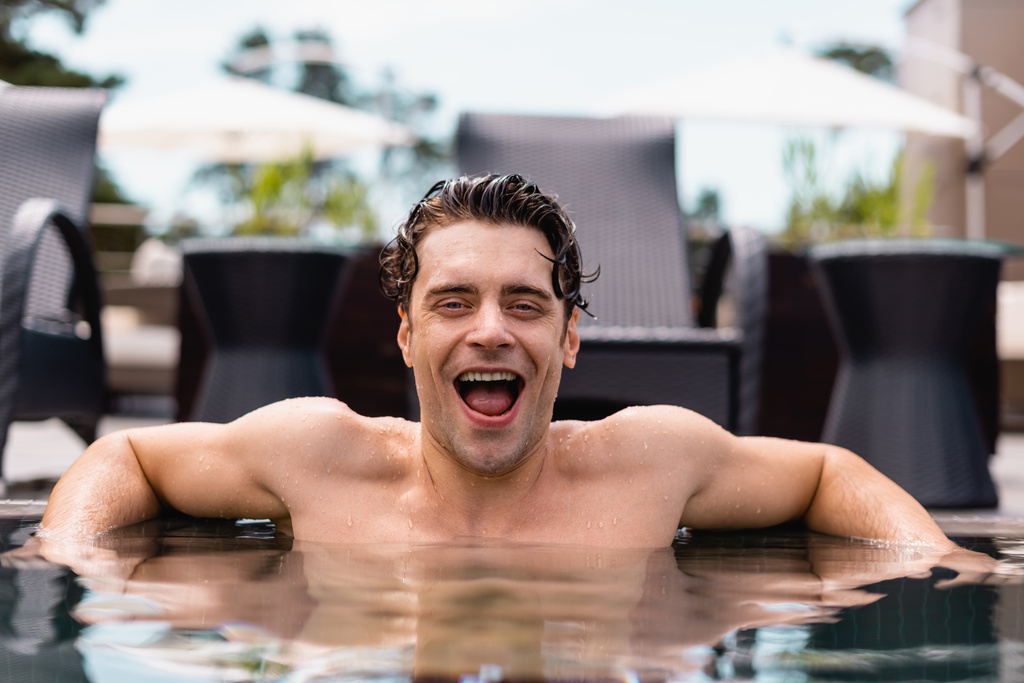excité et humide homme regardant caméra dans la piscine  - Photo, image