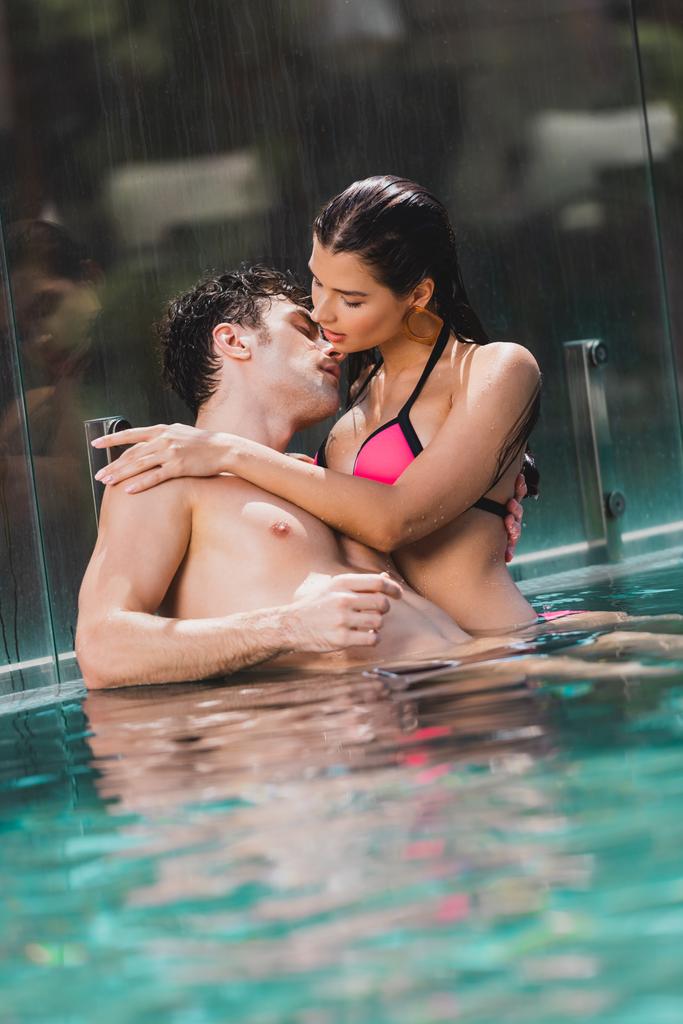 sexy hombre abrazando con mojado chica en piscina
  - Foto, imagen