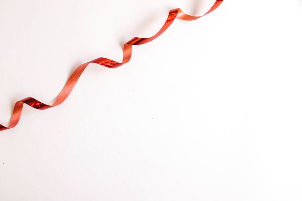 Red ribbon for gift wrapping. Decor for the holidays. Spiral of tape. - Photo, Image