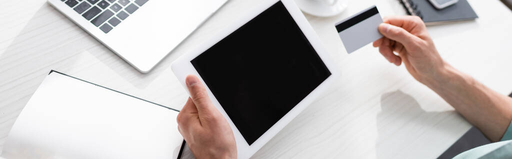 Panoramatická plodina muže držícího digitální tablet a kreditní kartu u stolu, koncept vydělávání online - Fotografie, Obrázek