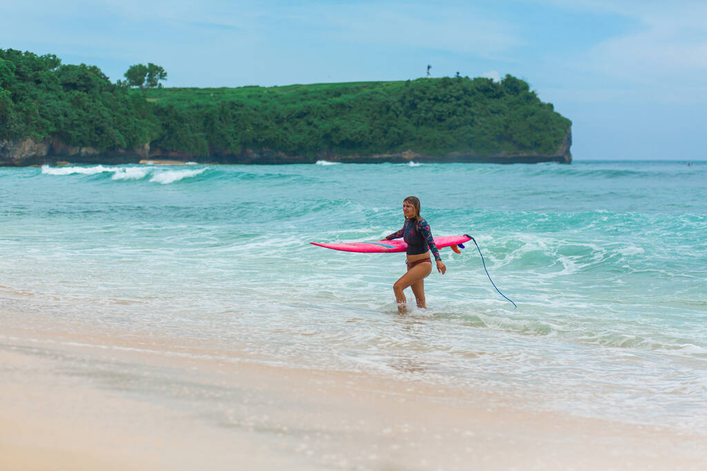 Sexy štíhlá dívka s surfovací prkno na tropické písečné pláži. Zdravý aktivní životní styl v letním povolání. Bali, Indonésie - 03 / 24 / 2018 - Fotografie, Obrázek
