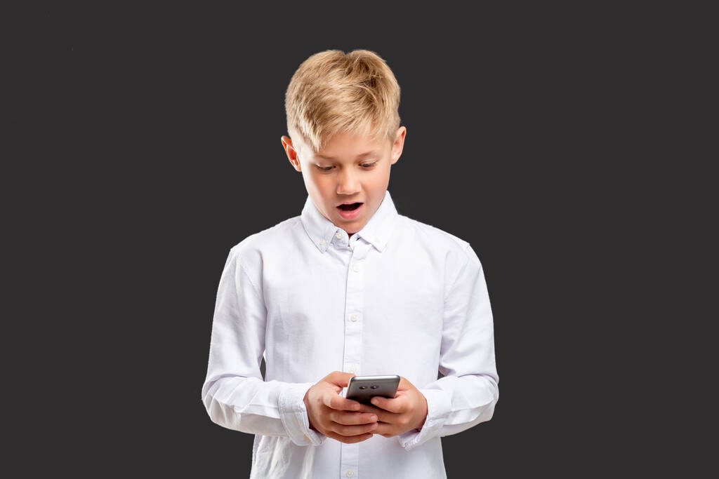 comunicazione online sorpreso ragazzo telefono di lettura - Foto, immagini