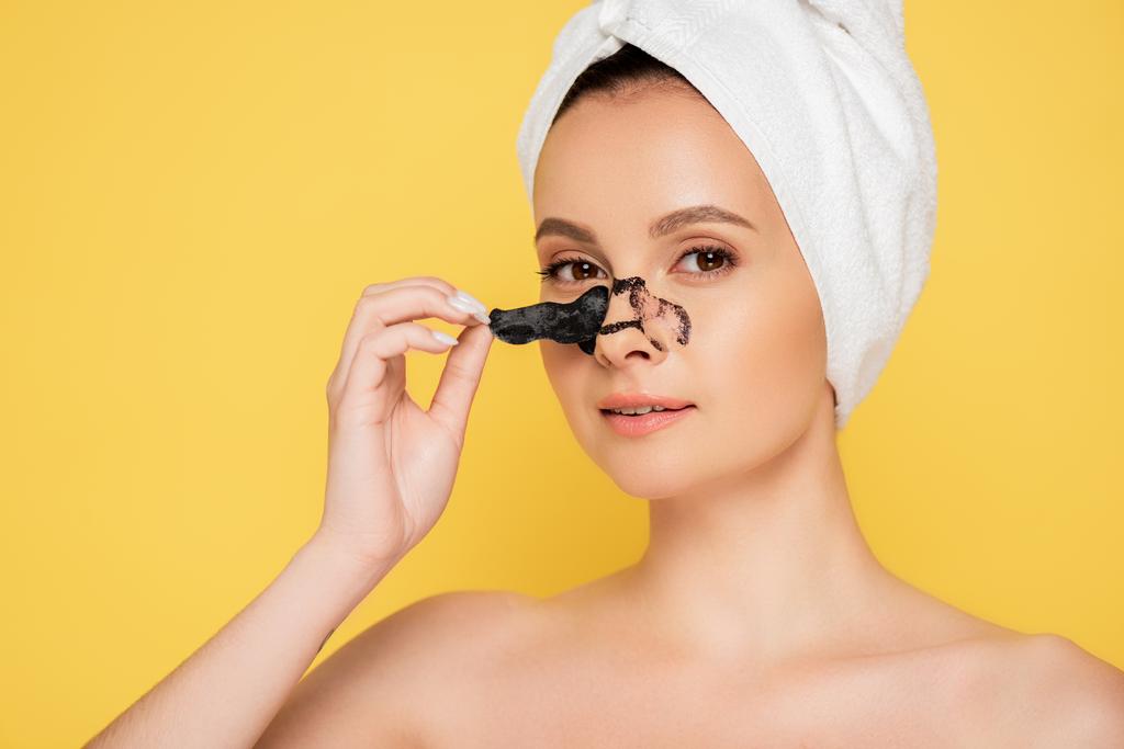 beautiful naked woman with towel on head removing blackheads on nose isolated on yellow - Photo, Image