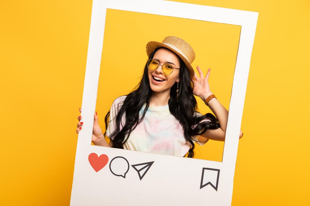 szczęśliwy brunetka dziewczyna w lato strój pozowanie w sieci społecznej ramki na żółtym tle - Zdjęcie, obraz