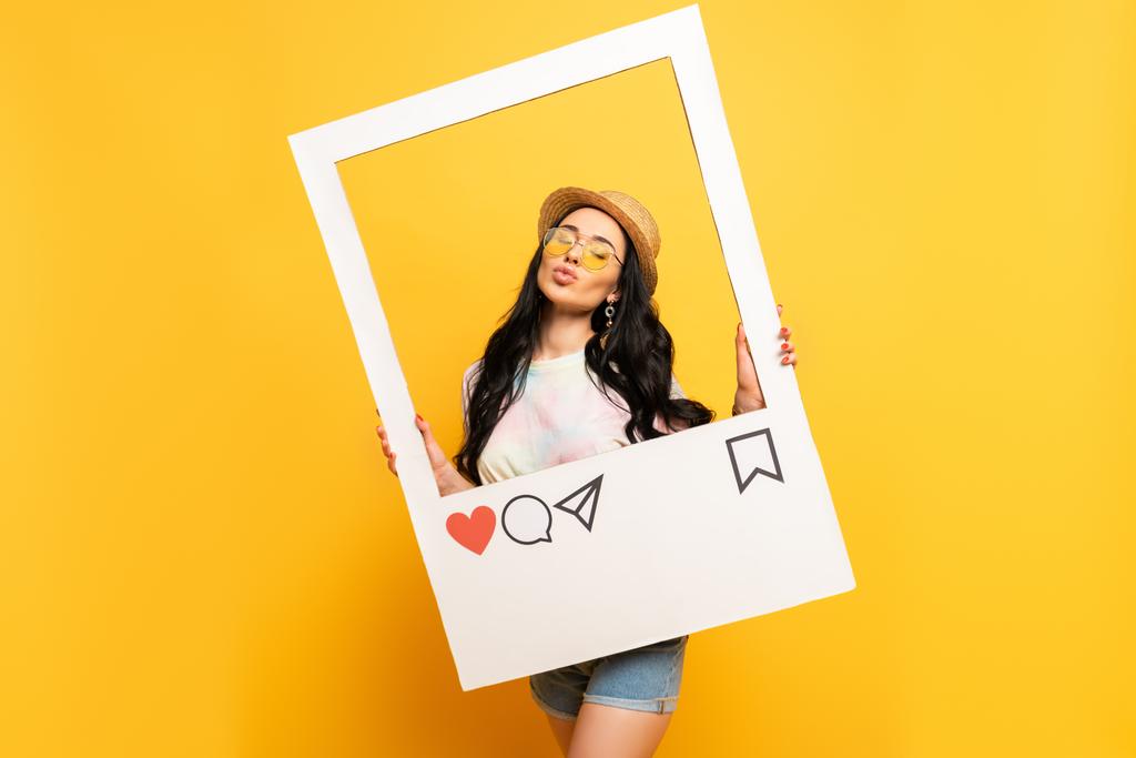 brünettes Mädchen im Sommer-Outfit posiert schmollende Lippen in sozialem Netzwerk Rahmen auf gelbem Hintergrund - Foto, Bild