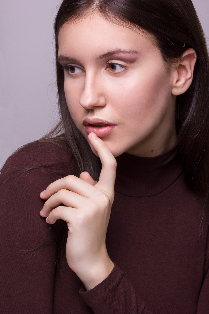 Studio emotional portrait of a beautiful young brunette woman with natural make-up - Photo, Image