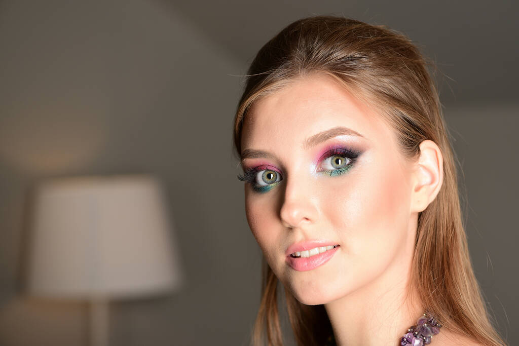 Girl in room with grey walls wearing colourful makeup - Photo, Image