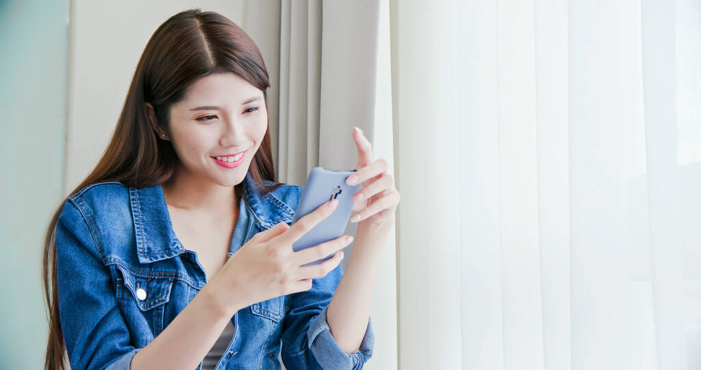 Азиатская красота использовать смартфон для развлечения дома
 - Фото, изображение