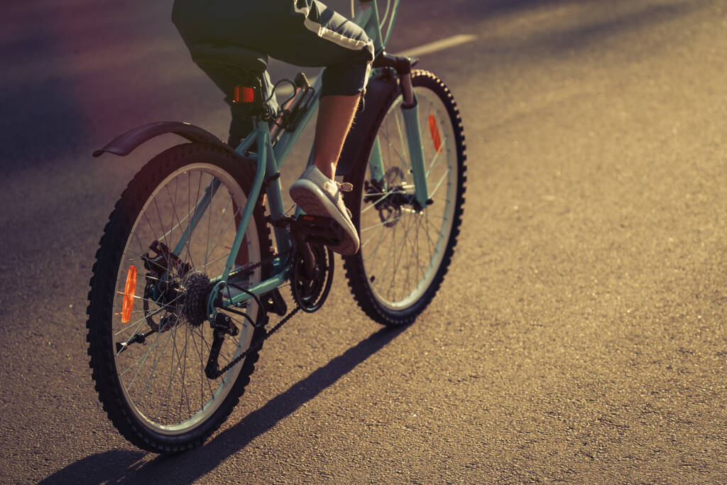 Dívka Kid jízda na kole v létě ve městě při krásném západu slunce   - Fotografie, Obrázek