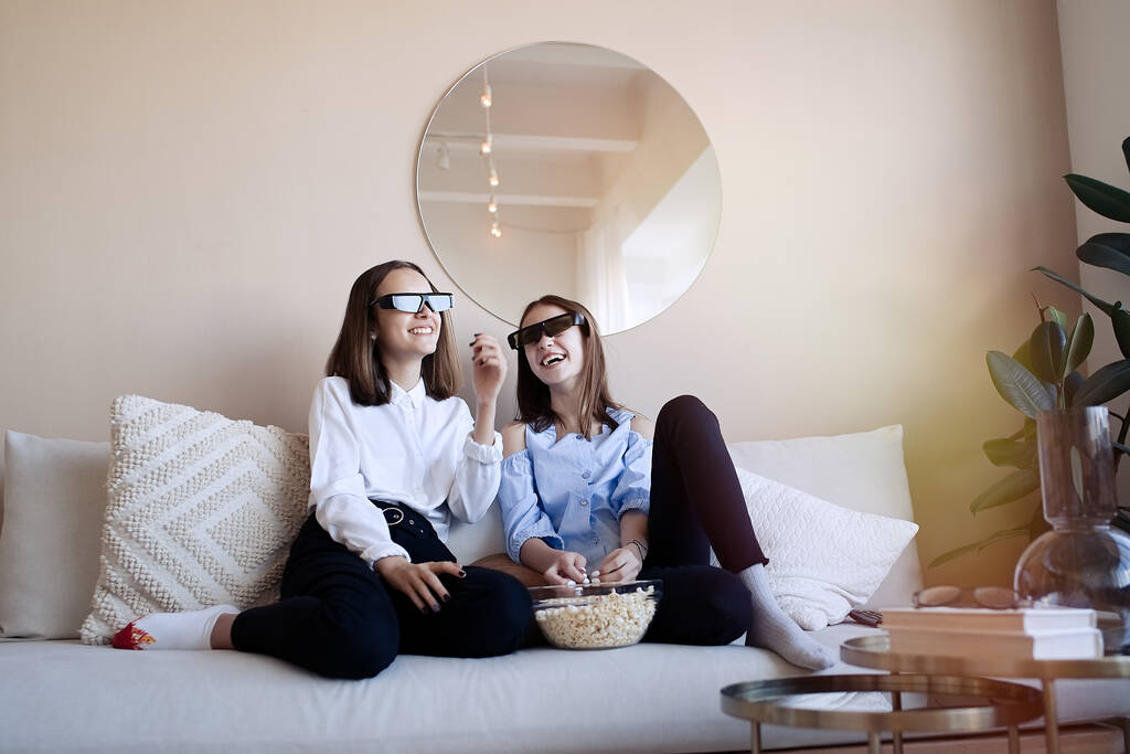 Boldog barátok vagy tizenéves lányok 3D-s szemüveggel eszik popcorn és filmet néz otthon   - Fotó, kép