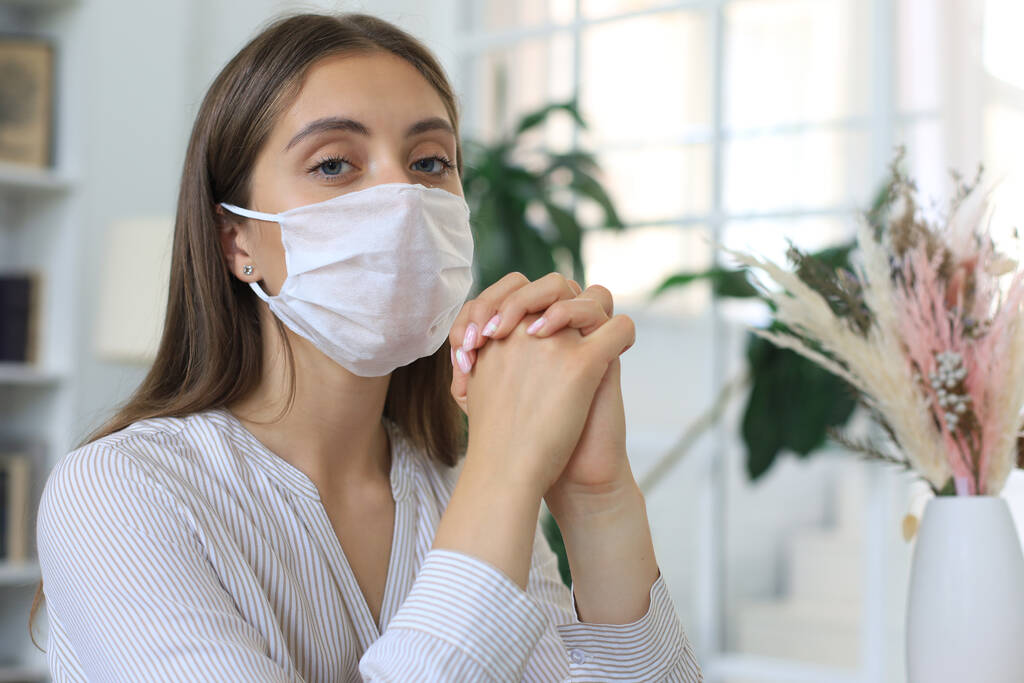 Giovane donna in maschera medica a casa durante la situazione epidemica - Foto, immagini
