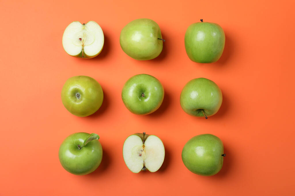 Смачні зелені яблука на помаранчевому фоні, плоский лежак
 - Фото, зображення