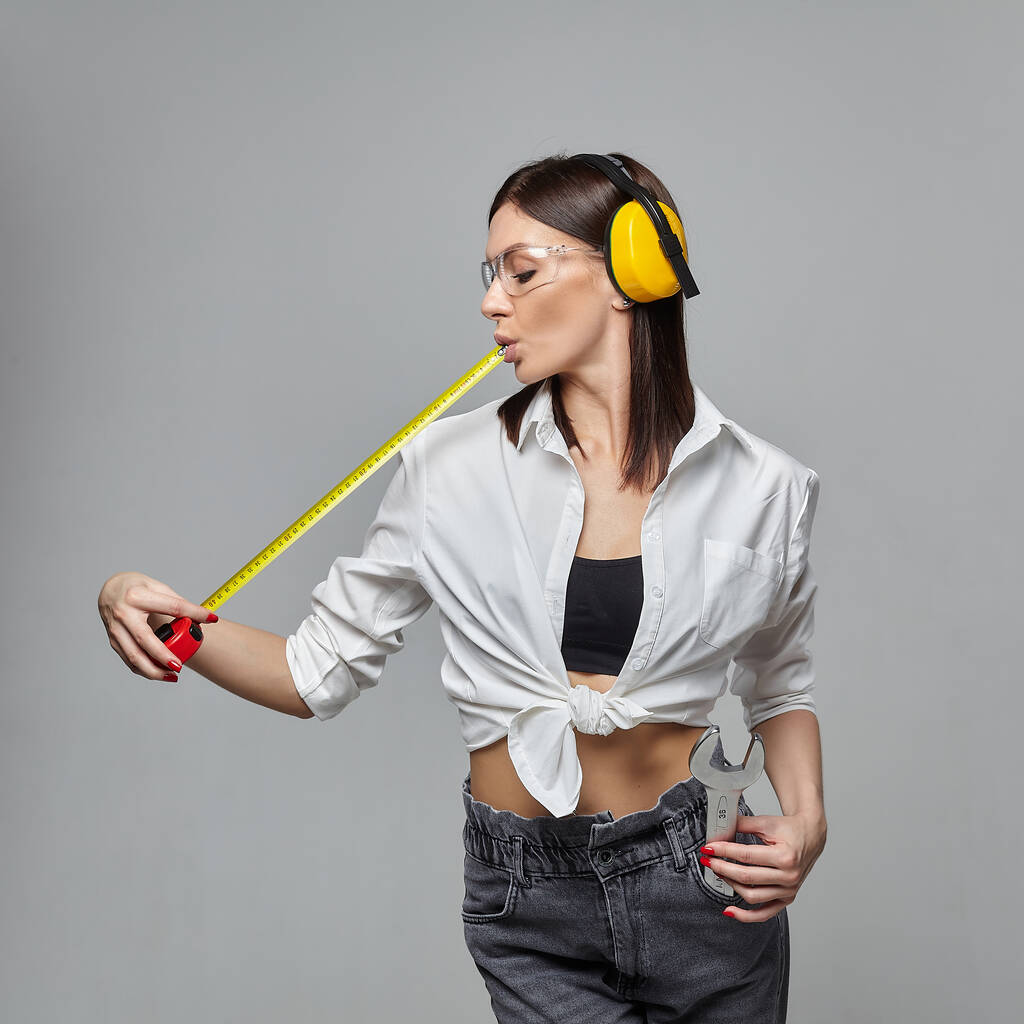 sexy girl holding a measuring tape. concept of advertising and construction services... - Photo, Image