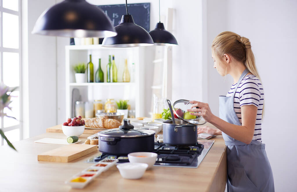 Gyönyörű fiatal nő főzés a konyhában otthon - Fotó, kép
