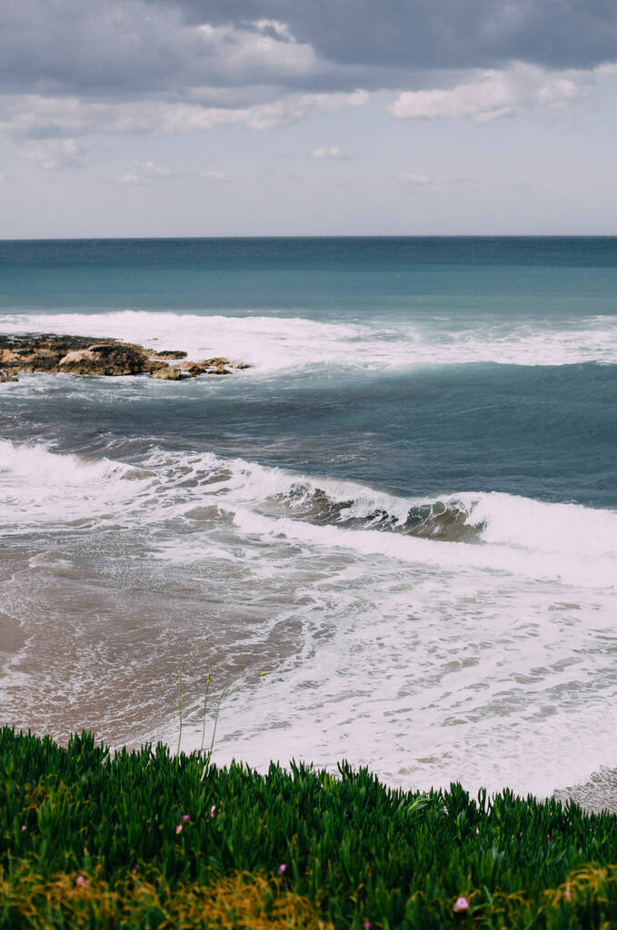 Foto vertical del paisaje marino. Hermosa naturaleza en la isla. Hierba verde, olas
. - Foto, imagen