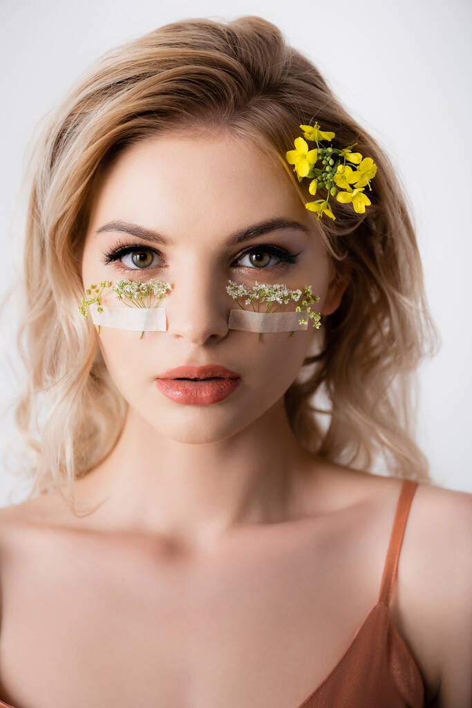 piękna blondynka z dzikimi kwiatami pod oczami odizolowane na białym - Zdjęcie, obraz