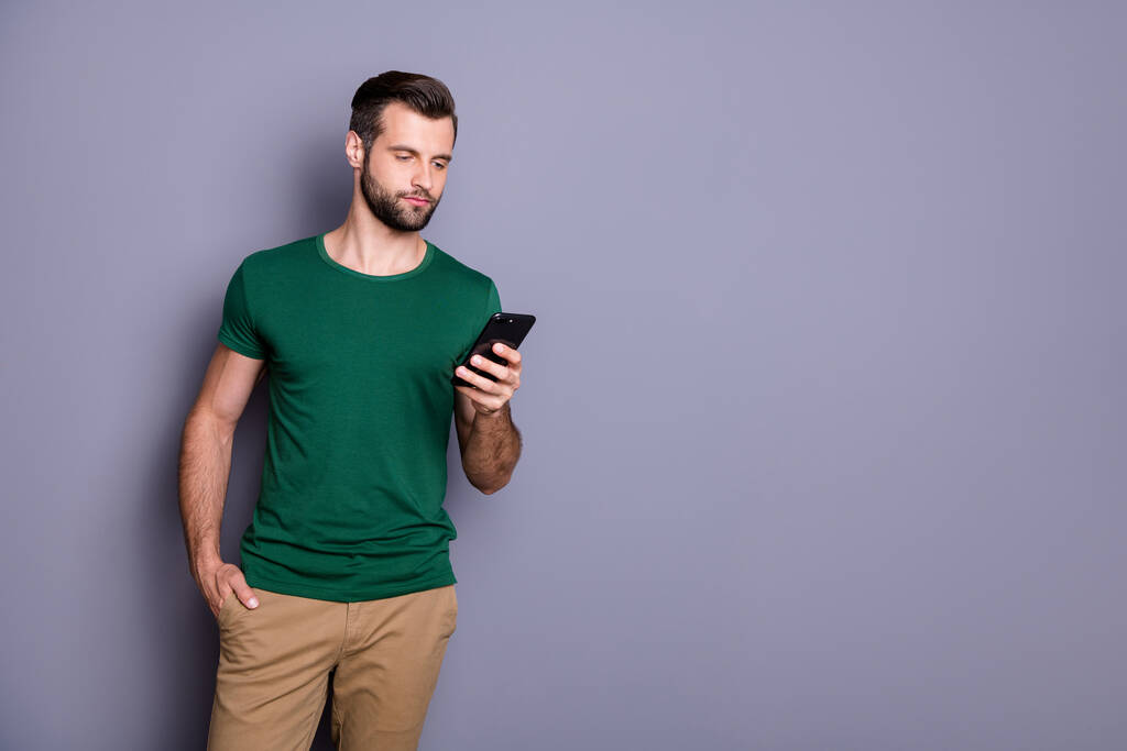 Portrait of focused guy use smart phone read coronavirus social network information post comment feedback wear casual style clothes isolated over gray color background - Photo, Image