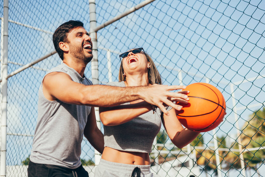 Coppia divertirsi giocando a basket all'aperto nella giornata di sole. - Foto, immagini