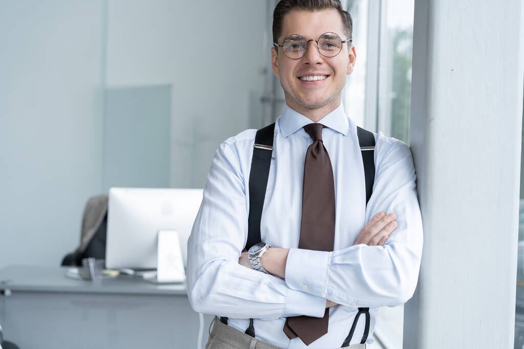 Portrait Of Businessman Standing By Window In Office. - Photo, Image