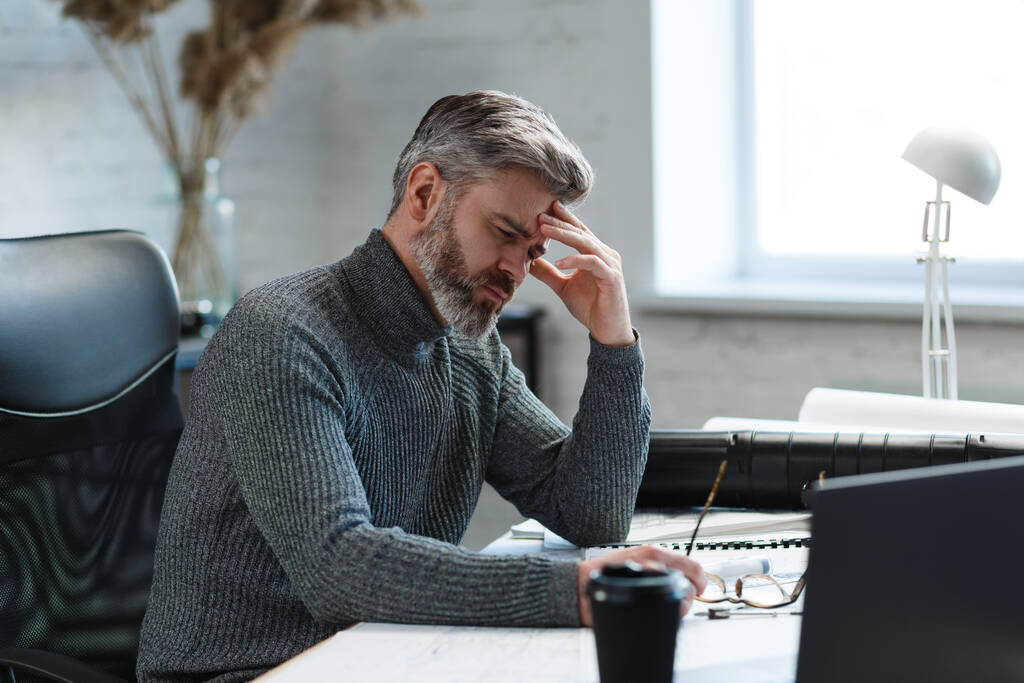 Tired architect working overtime in office. Stressed businessman have financial problems and searching ideas to overcome financial crisis. Entrepreneur in bankruptcy. Burnout and overwork concept - Photo, Image