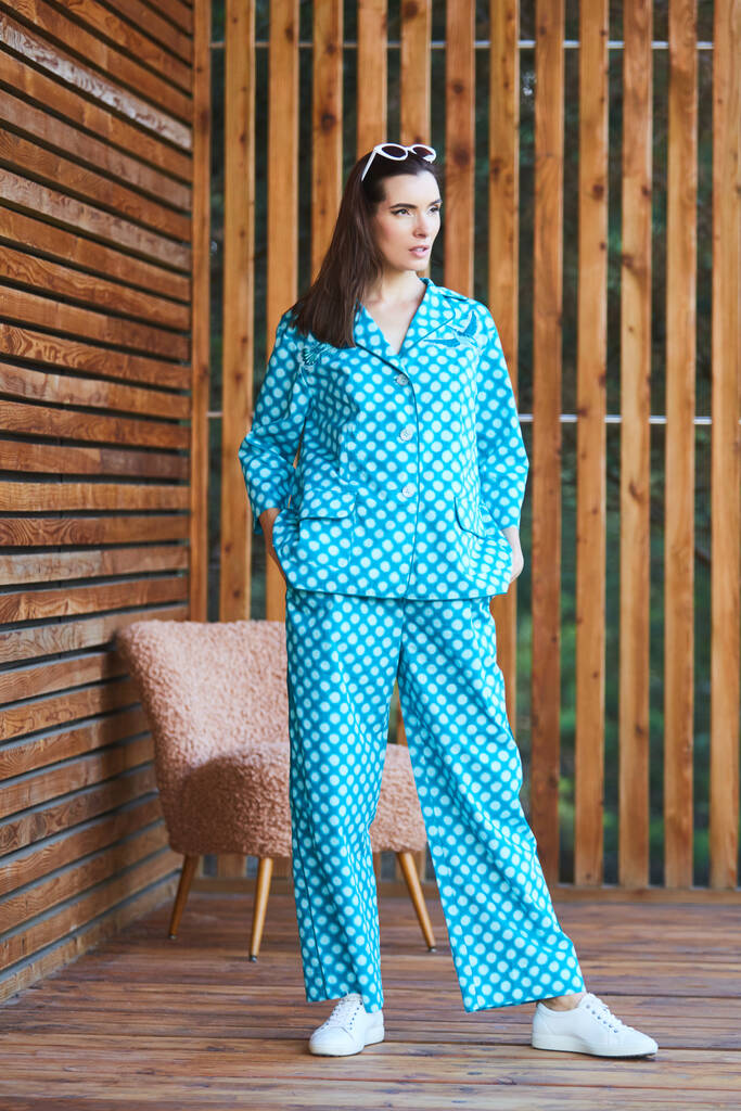 Žena stojící v pyžamu s puntíky na dřevěném pozadí v celé délce. Kavkazský model ženy. - Fotografie, Obrázek