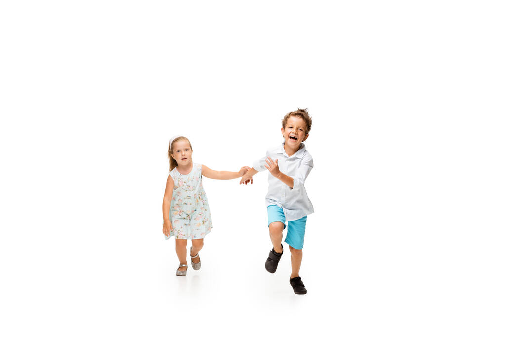 幸せな子供たち、小さな白人の男の子と女の子ジャンプし、白の背景に隔離された実行 - 写真・画像
