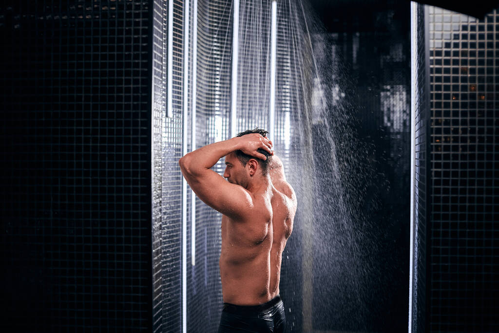 熱い仕事の日の後に自分自身をリフレッシュし、シャワーを浴びてハンサムな男. - 写真・画像
