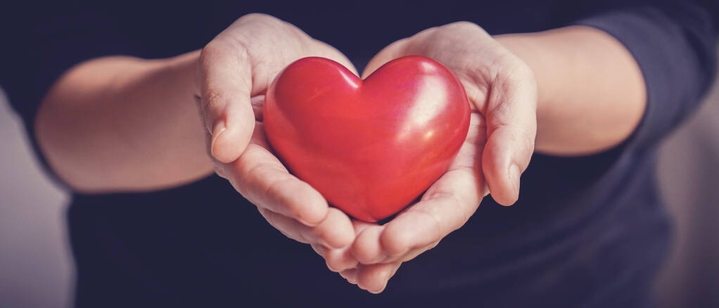 Frau mit rotem Herz, Krankenversicherung, Spende, fröhliches Charity-Freiwilligenkonzept, Welttag für psychische Gesundheit, Weltherztag - Foto, Bild