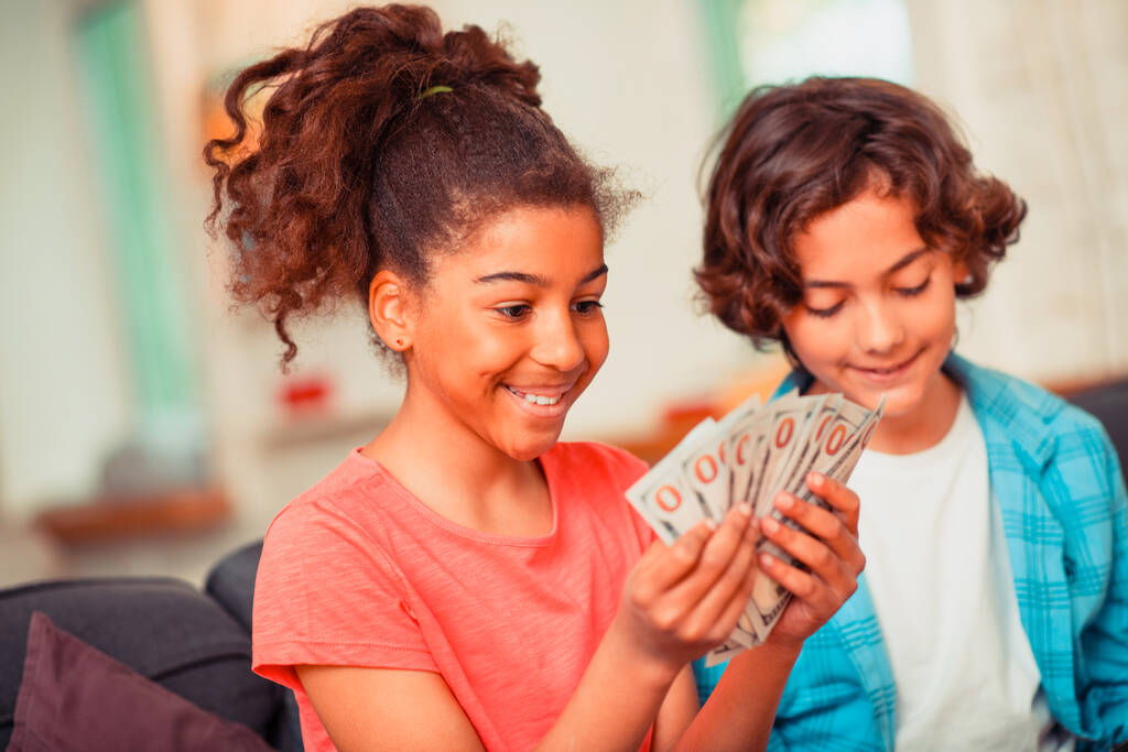 Glimlachend meisje met veel bankbiljetten - Foto, afbeelding