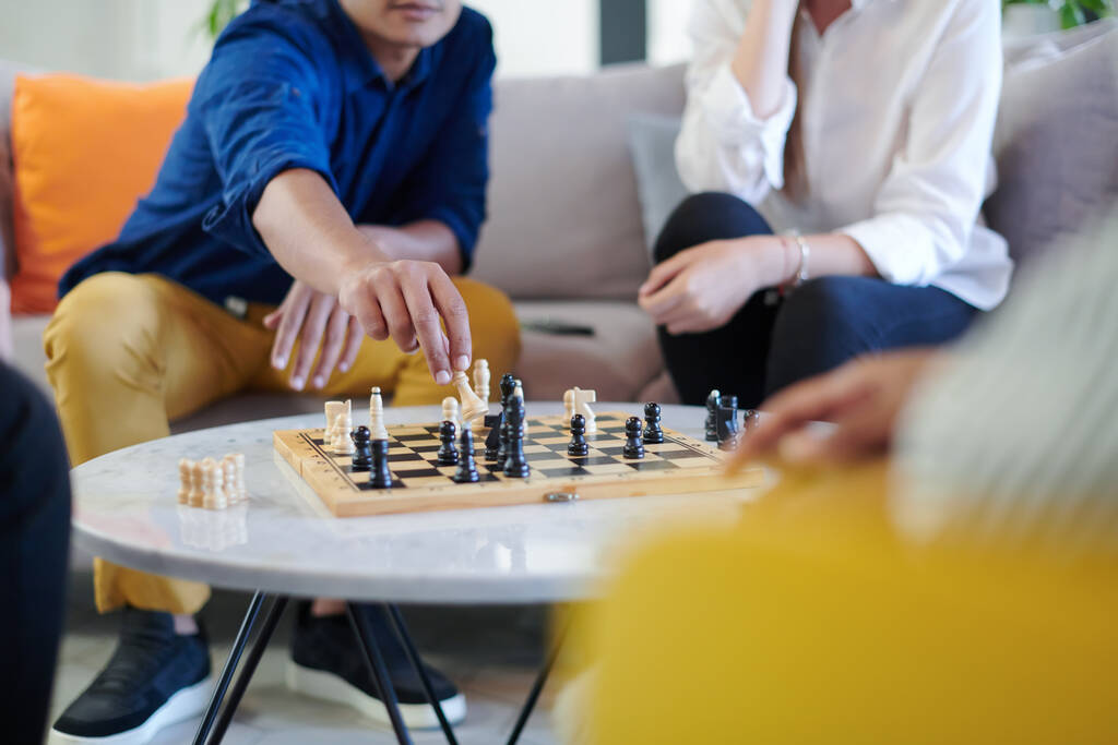 groupe multiethnique de gens d'affaires jouant aux échecs tout en faisant une pause dans l'espace de détente au bureau de démarrage moderne - Photo, image