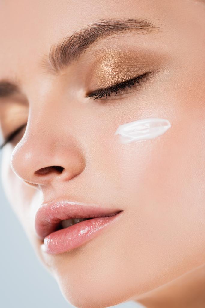 primer plano de la crema cosmética en la cara limpia de la mujer bonita con los ojos cerrados
 - Foto, imagen