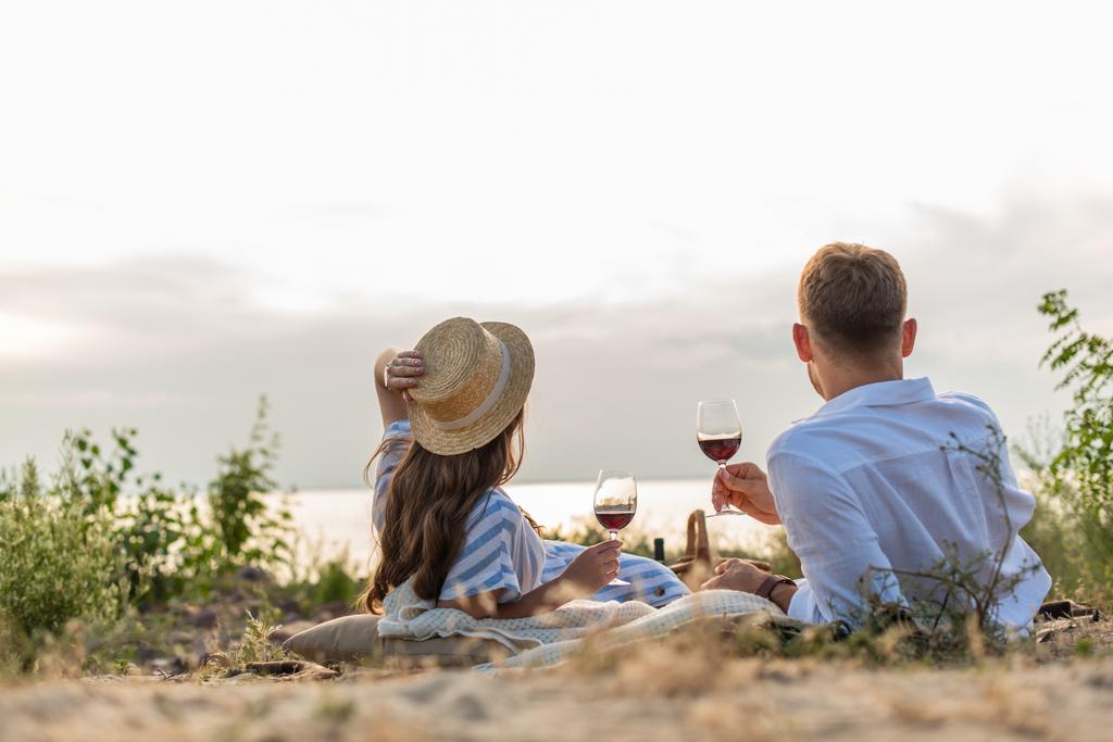 back view of couple holding glasses with red wine outside  - Photo, Image
