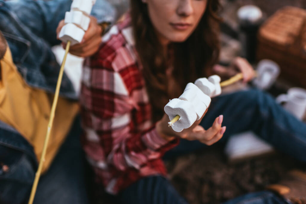 foco seletivo de marshmallows inchados em paus perto do par
 - Foto, Imagem