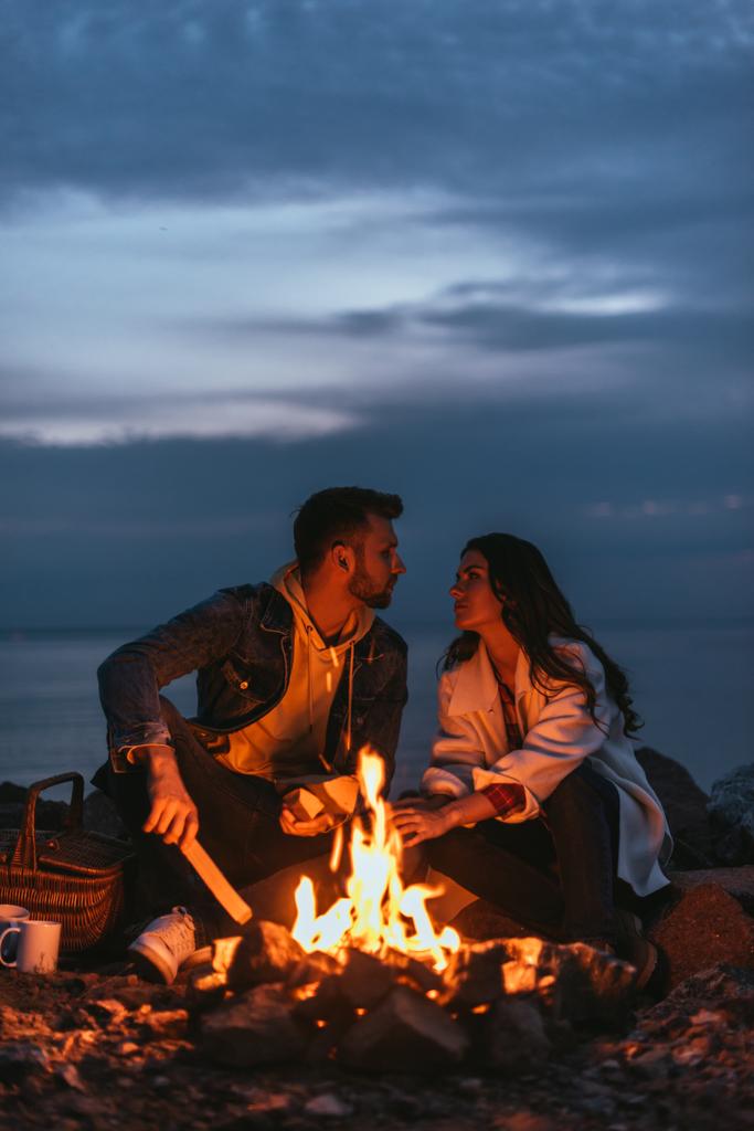 selektywne skupienie się pary patrzącej na siebie przy ognisku  - Zdjęcie, obraz