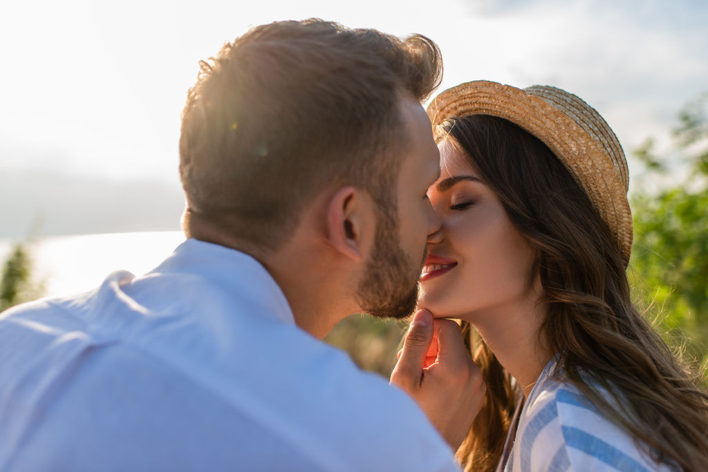 selettiva messa a fuoco di uomo barbuto baciare felice giovane donna  - Foto, immagini