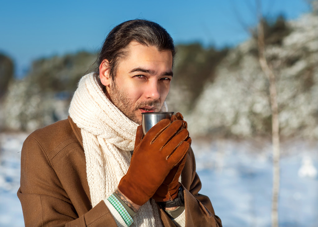 Joven hombre atractivo bebiendo té al aire libre en invierno
 - Foto, imagen