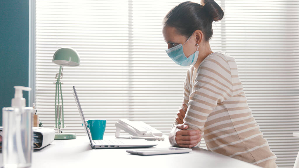 Mujer de negocios que trabaja en la oficina y lleva una máscara quirúrgica protectora, coronavirus covid-19 concepto de prevención
 - Foto, imagen
