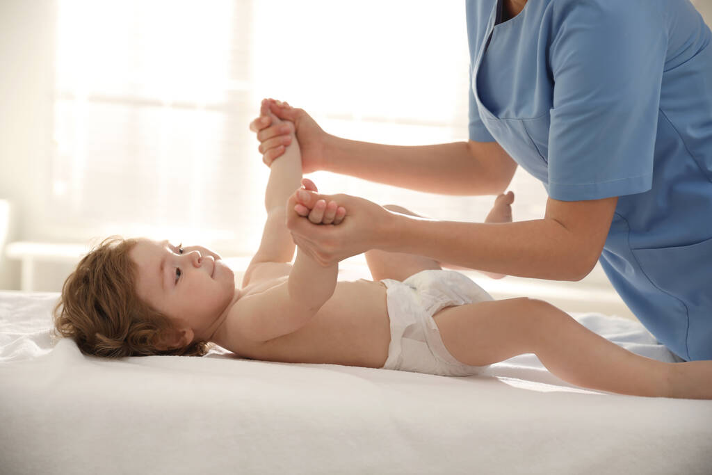 Orthopedist examining little baby on bed indoors - Photo, Image