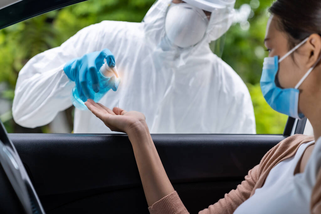 Lékařský personál dát alkohol gel dezinfekci rukou asijské ženy před coronavirus covid-19 test na řídit přes stanice v nemocnici. Nový normální zdravotní pohon přes služby a lékařské koncepce. - Fotografie, Obrázek