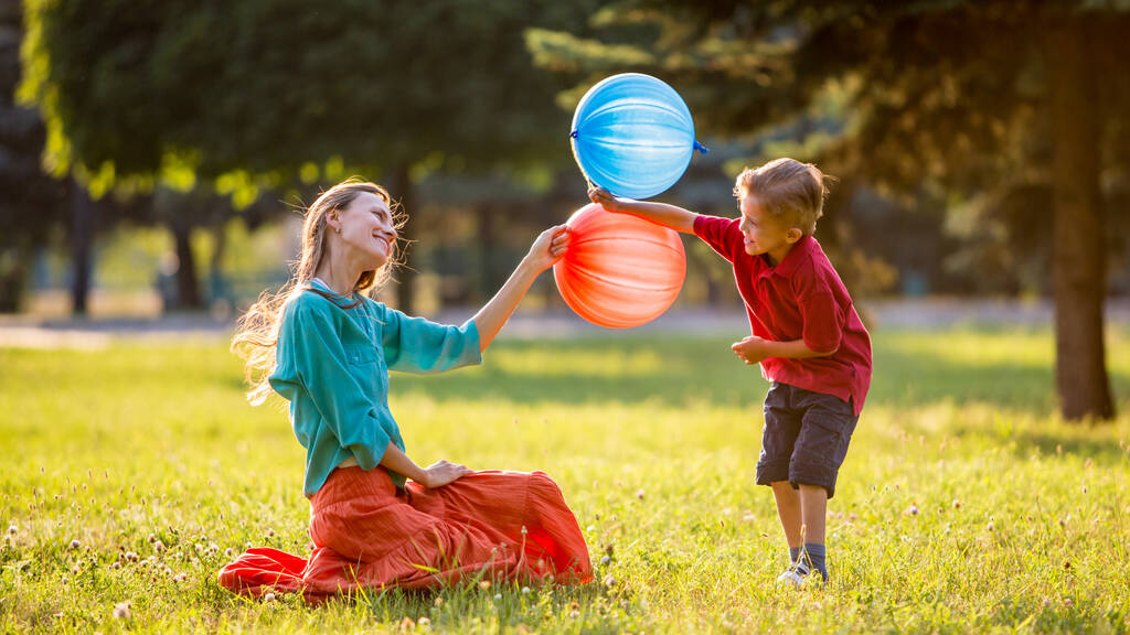 ευτυχισμένη μητέρα και γιος παίζουν έξω στο πάρκο - Φωτογραφία, εικόνα
