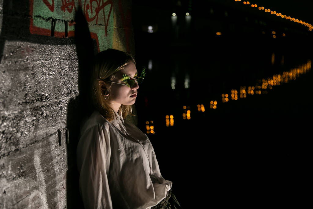 Kobieta w nocy z tłem graffiti. Niski klucz - Zdjęcie, obraz