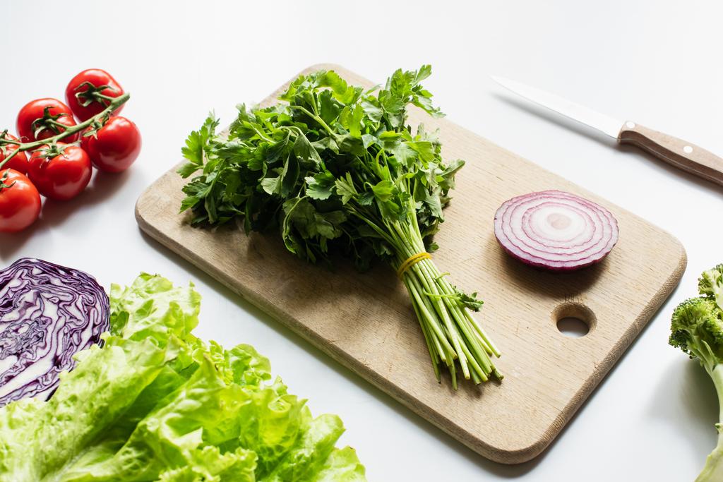 assorted fresh vegetables and wooden cutting board with red onion and parsley on white background - Photo, Image