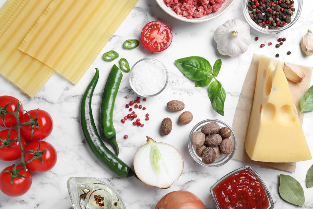 Verse ingrediënten voor lasagne op witte marmeren tafel, plat gelegd - Foto, afbeelding