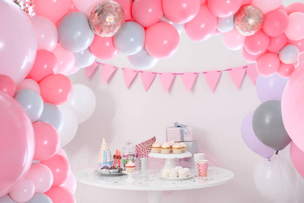 Baby shower party for girl. Tasty treats on table in room decorated with balloons - Zdjęcie, obraz