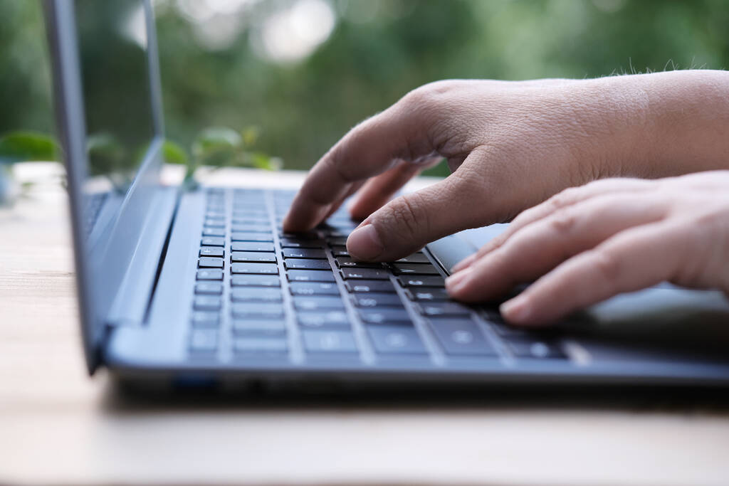mujer está escribiendo en el teclado portátil, enfoque selectivo, trabajando en la noche en el ordenador portátil de su casa, primer plano de las manos, concepto de trabajo remoto, cuarentena, downshifting - Foto, Imagen