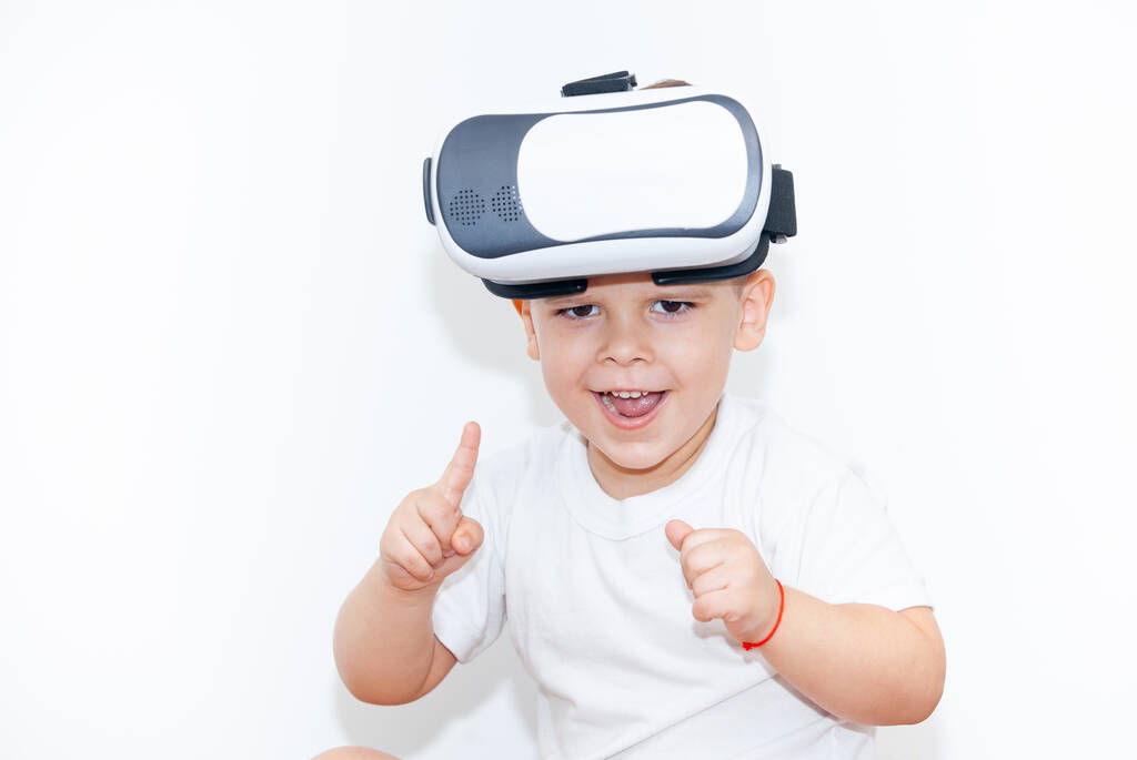 kleiner Junge mit Virtual-Reality-Brille auf weißem Hintergrund - Foto, Bild