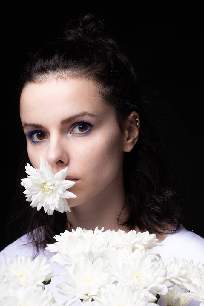 красива жінка з білими квітами на темному тлі
 - Фото, зображення