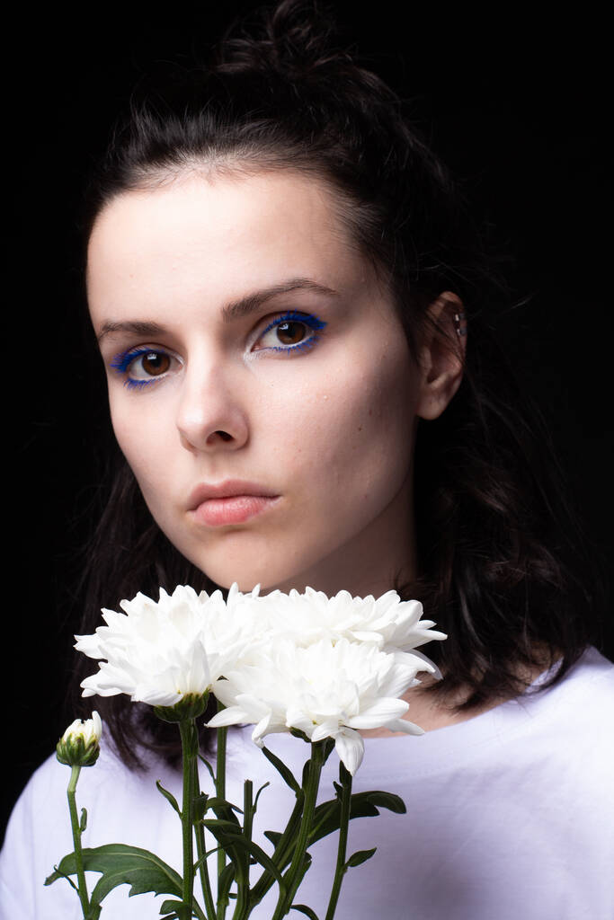 暗い背景に白い花を咲かせる美しい女性 - 写真・画像