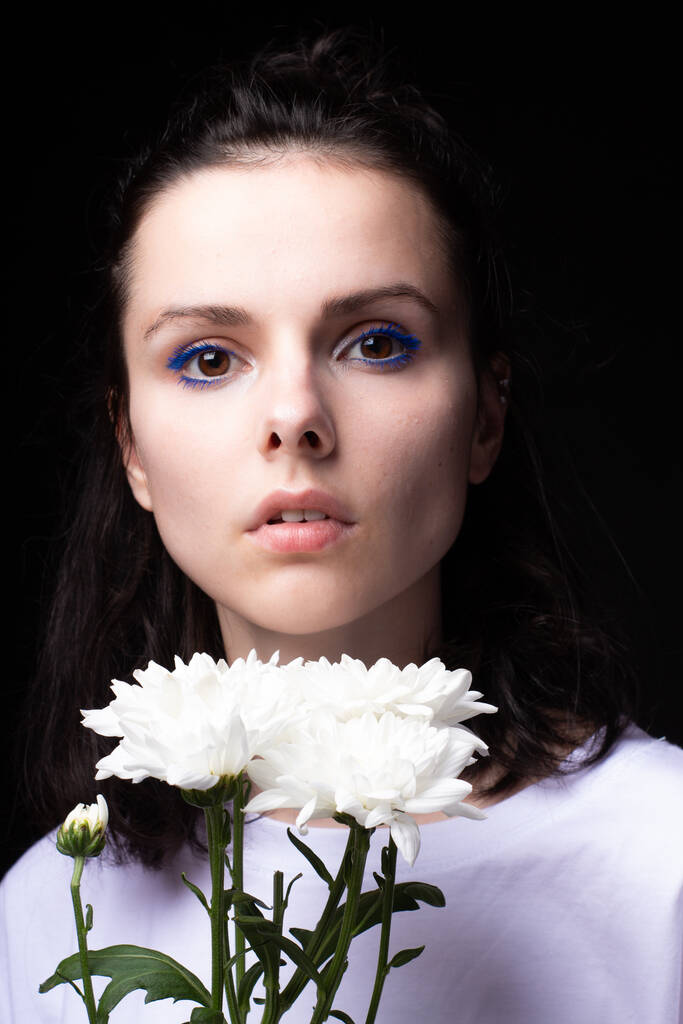 gyönyörű nő fehér virágok egy sötét háttér - Fotó, kép