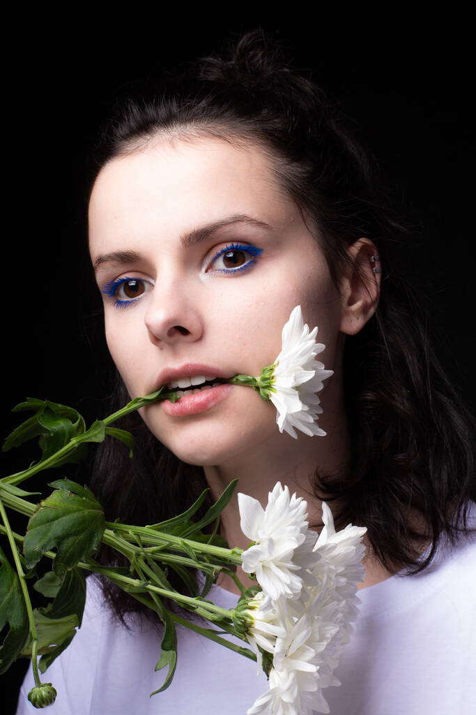 жінка їсть білі квіти на чорному фоні
 - Фото, зображення